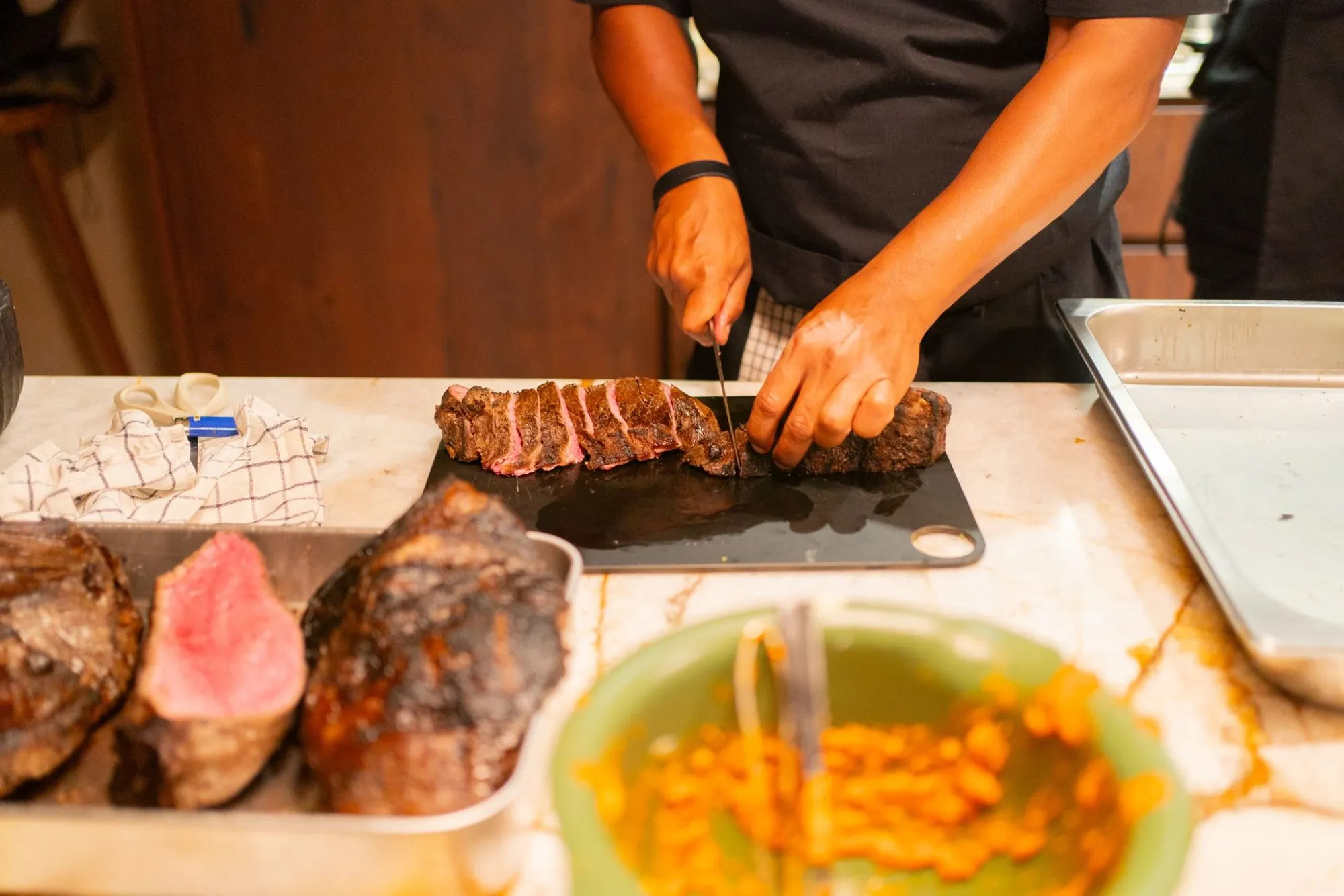 A chef slicing grilled beef
