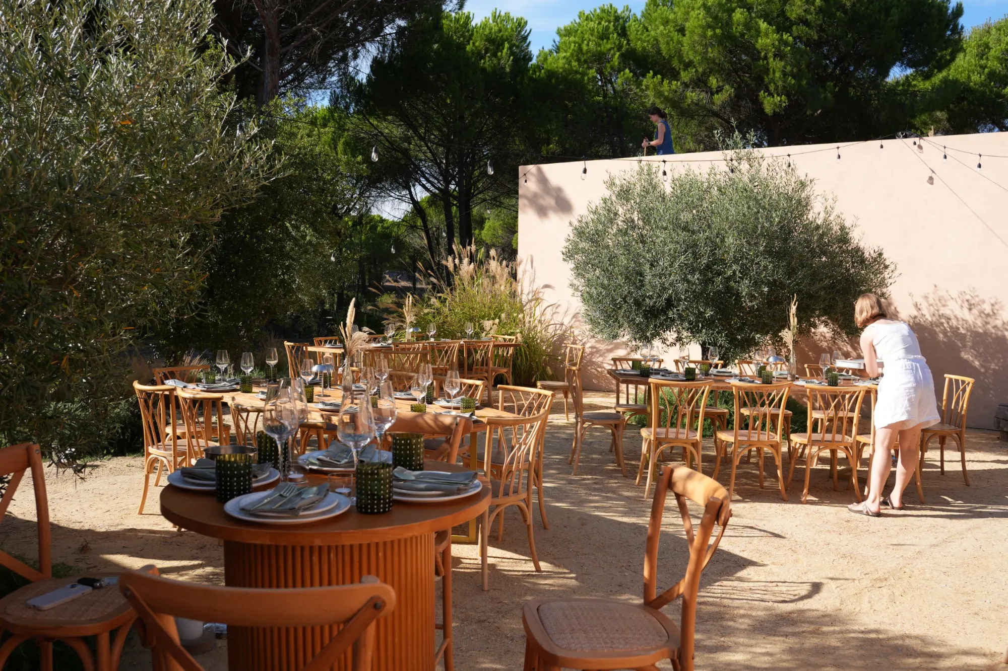 Dinner tables set under the olive trees at a villa