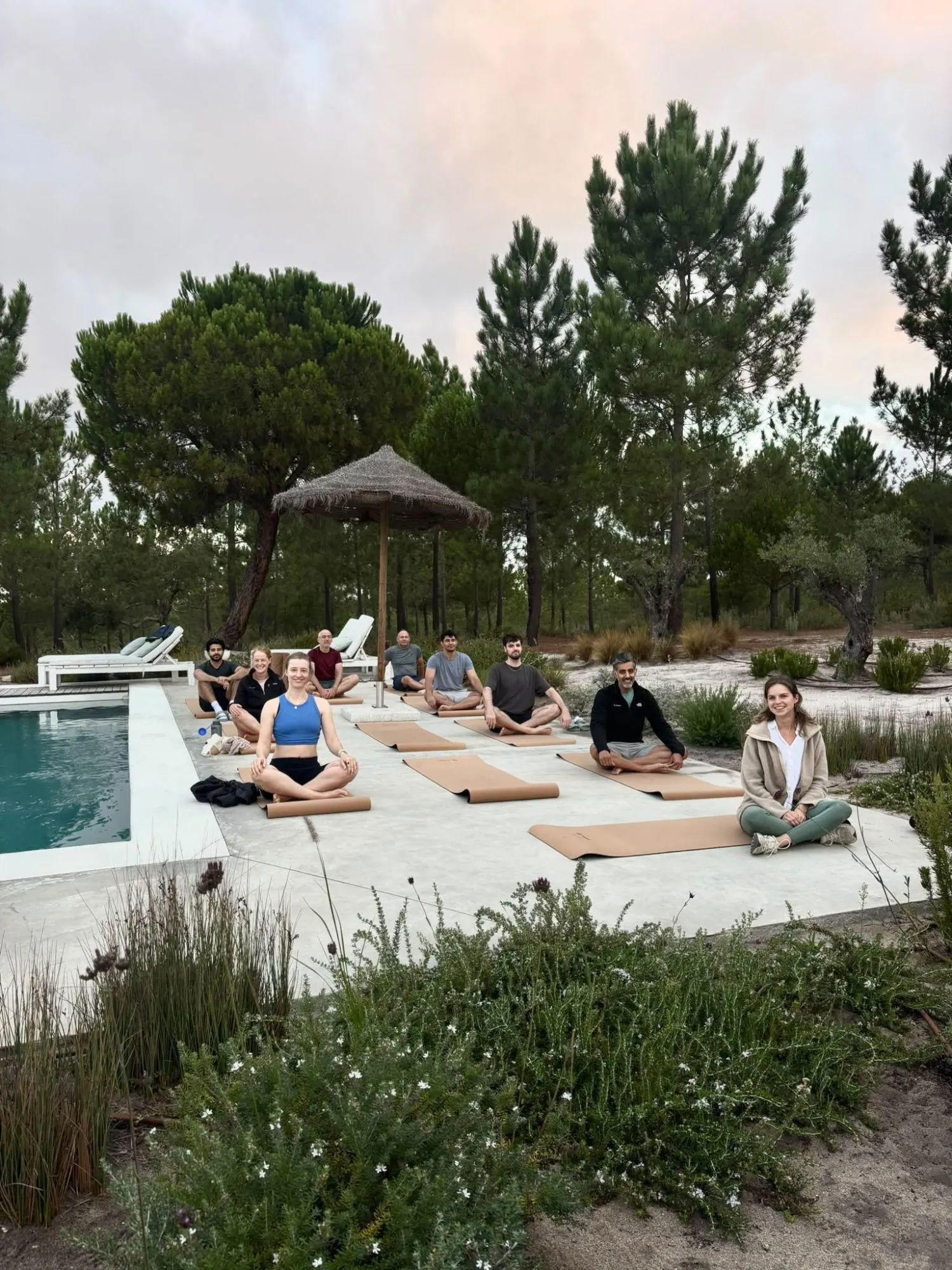 A team on yoga mats by the pool