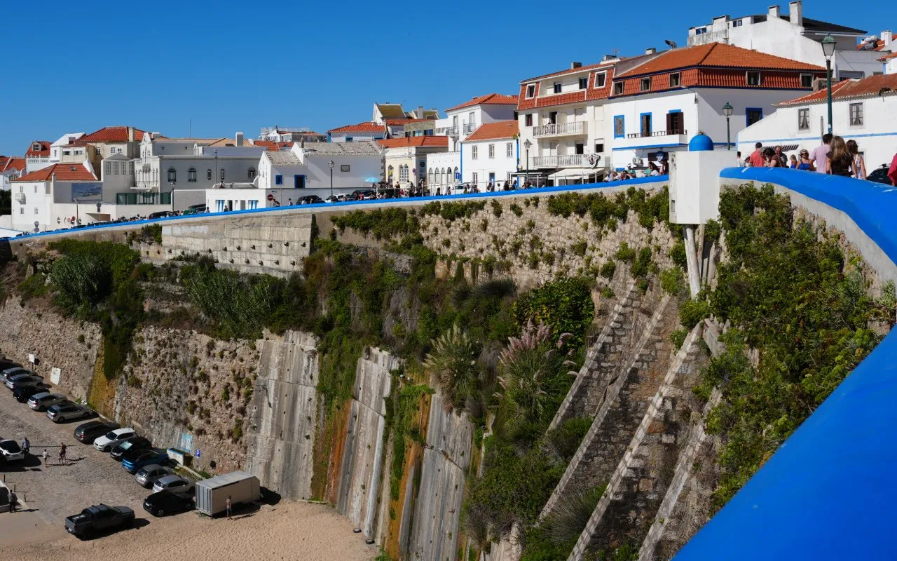 Whitewashed houses with orange roofs above the harbour cliff in Ericeira