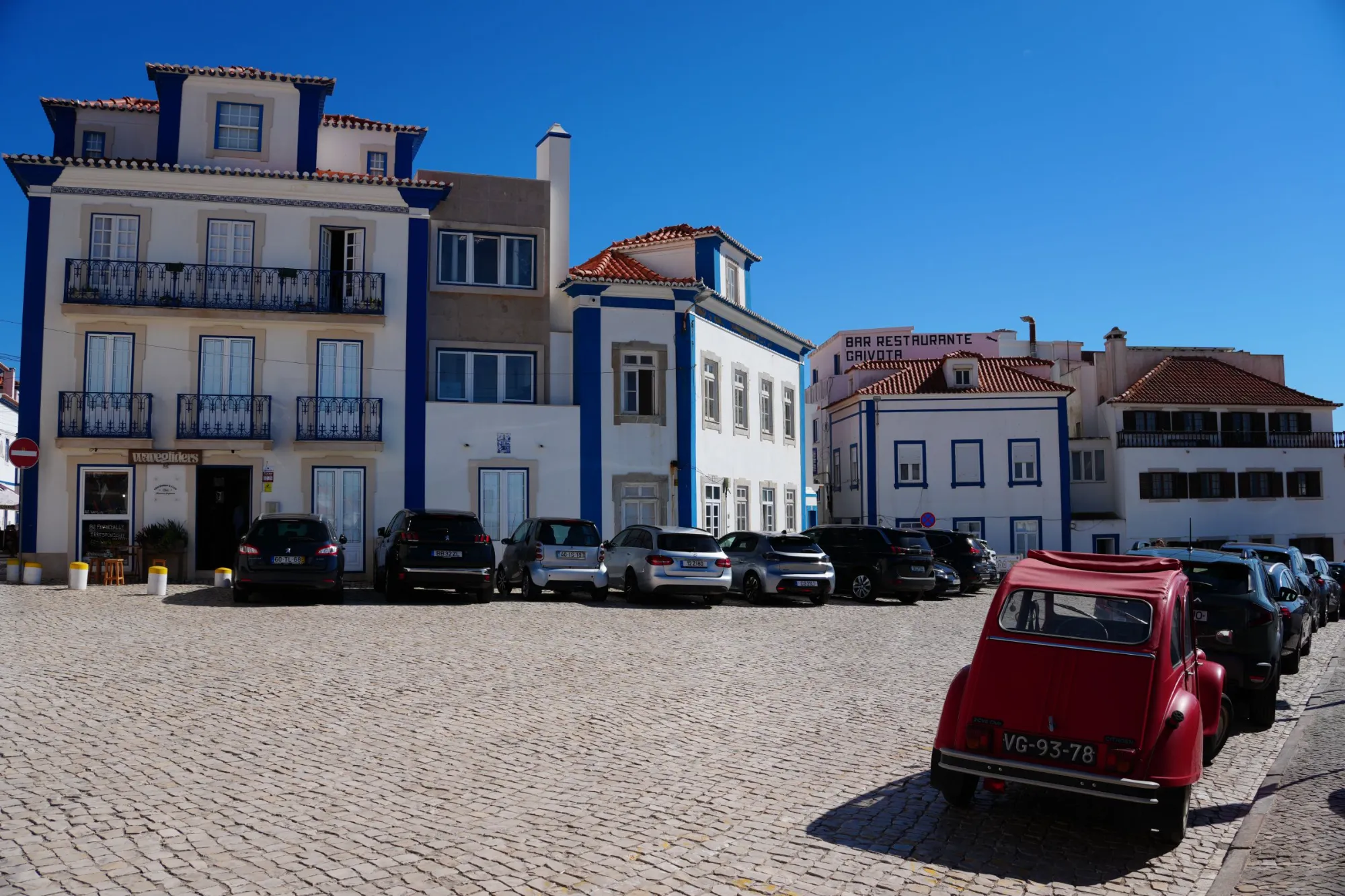 A cobbled square with a red Citroën 2CV