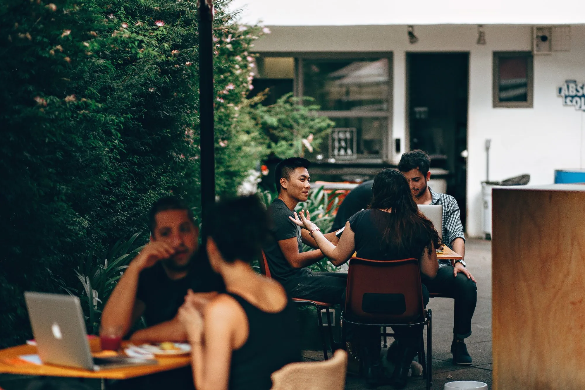 A team talking round a table in a leafy garden